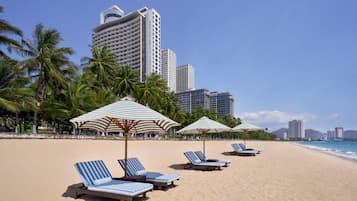 On the beach, white sand, sun loungers, beach umbrellas