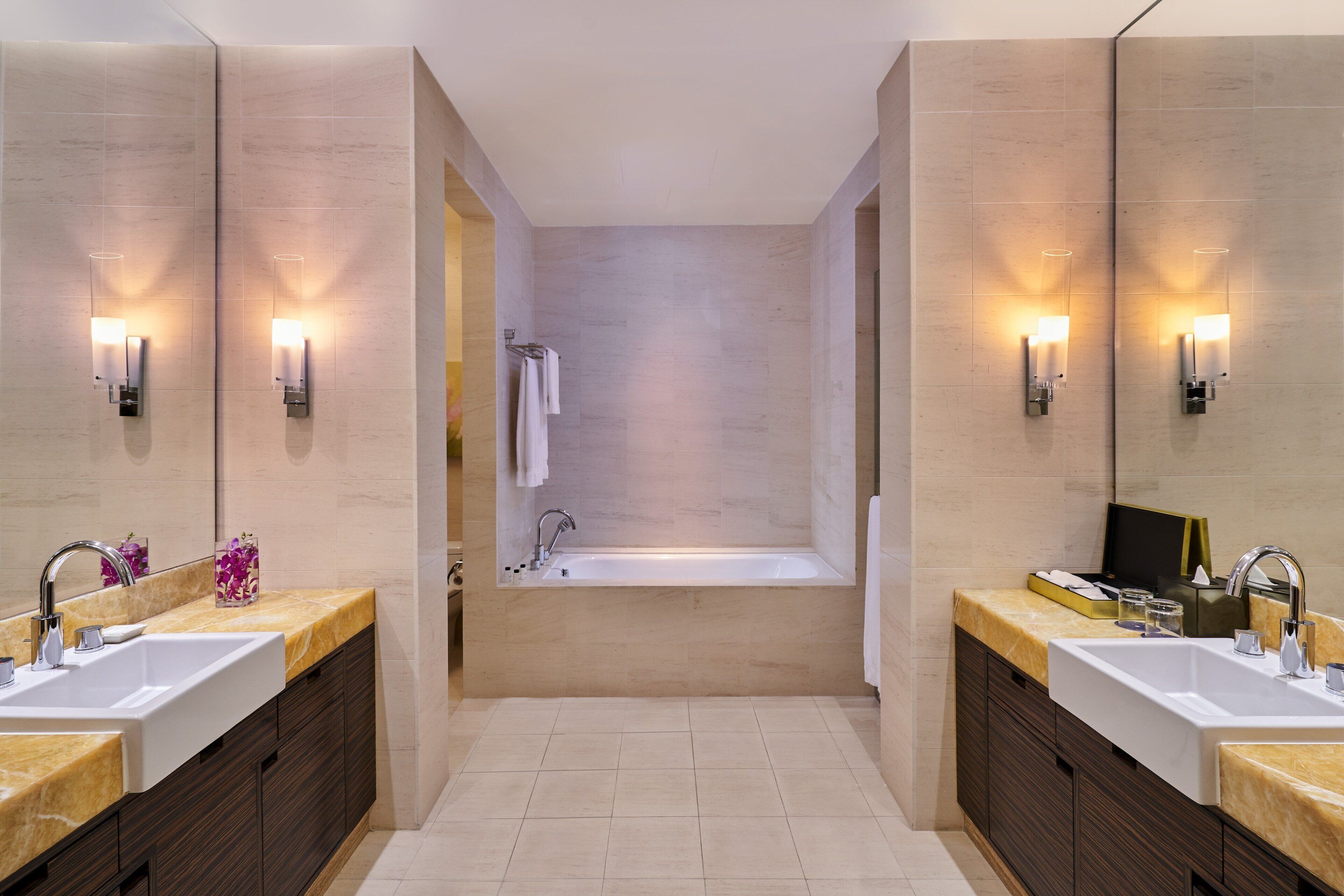 Ein modernes Badezimmer mit zwei Waschbecken, einer großen Badewanne und einem Spiegel.