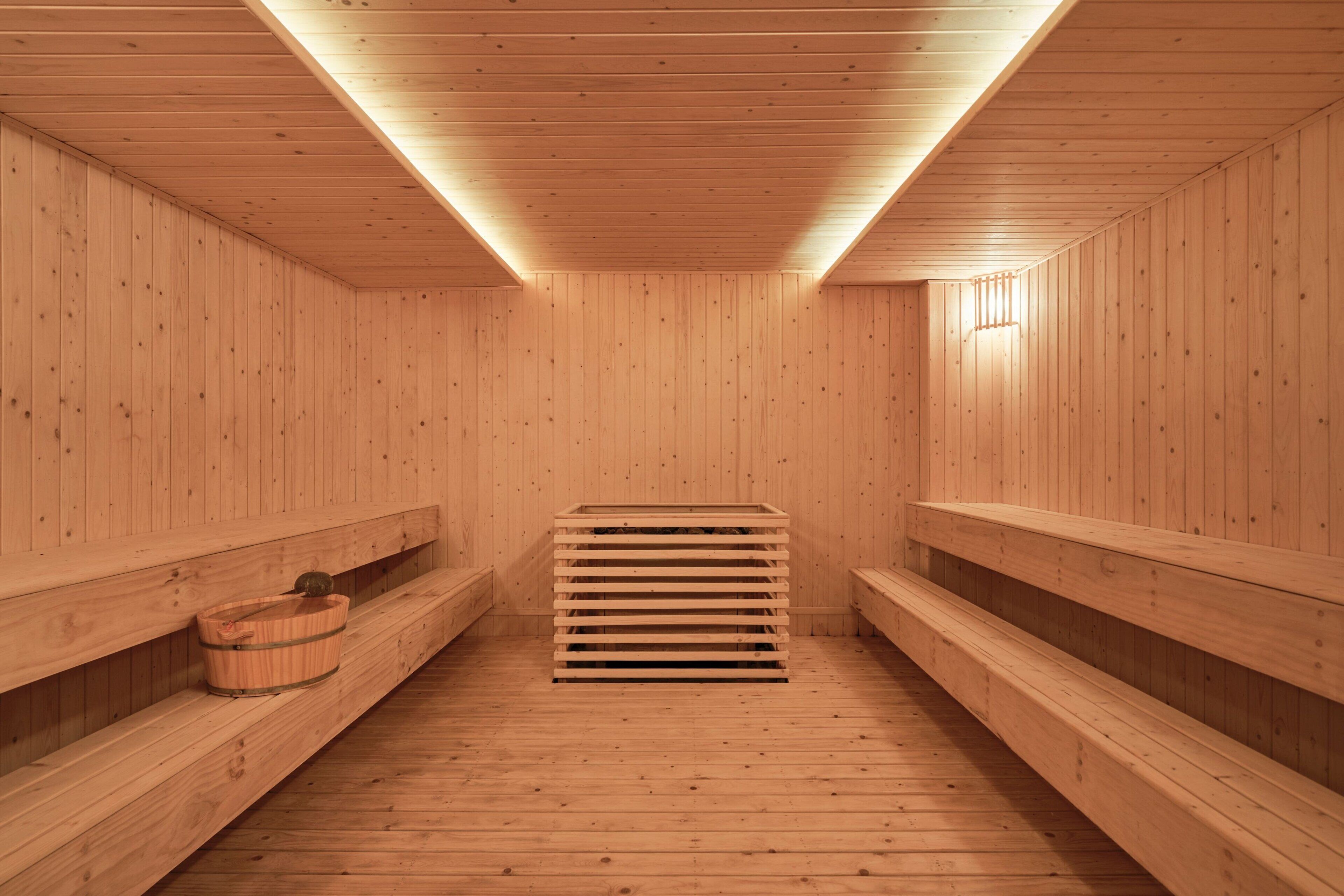 A sauna with wooden benches and a central bench.