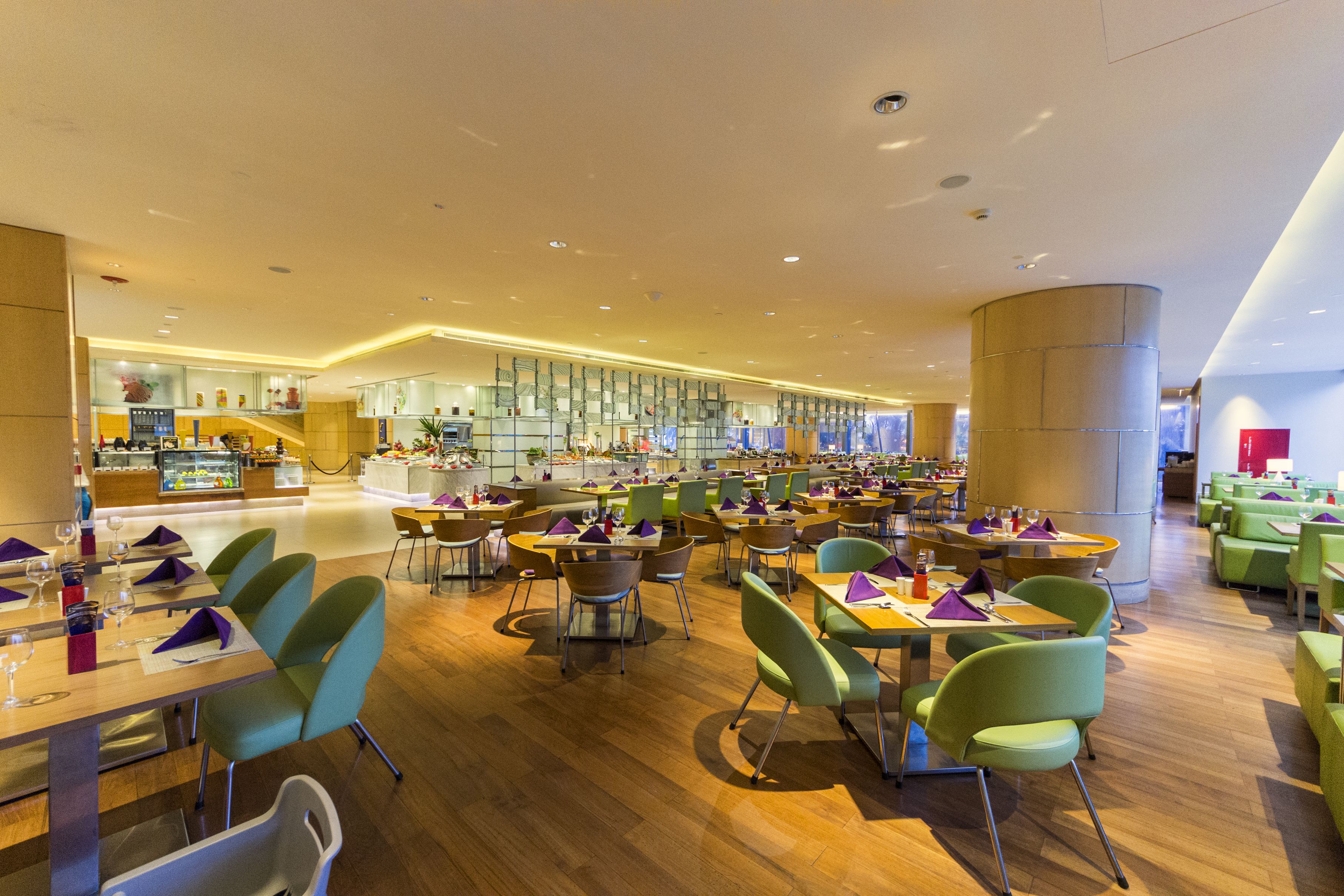 Ein geräumiges Restaurant mit verschiedenen Essbereichen, Holzböden und modernen Stühlen.