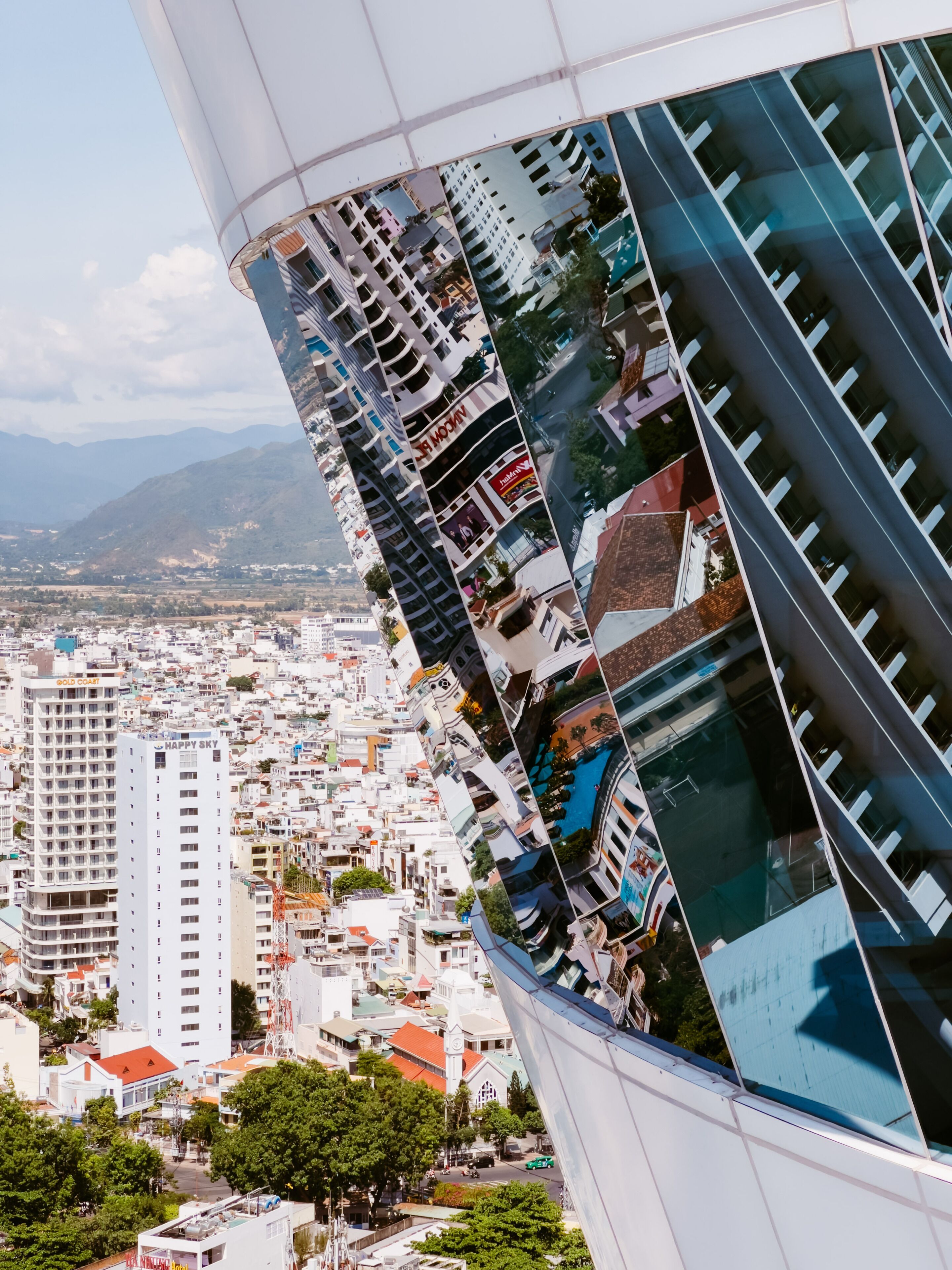 A modern building with a curved facade reflecting the surrounding cityscape.