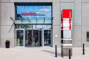 The InterCity Hotel entrance with a glass facade, revolving doors, and a prominent red and white sign. - IntercityHotel Mannheim (Mannheim)