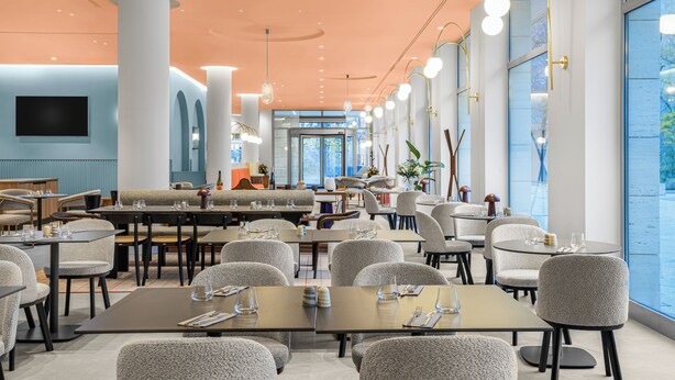 A modern restaurant with high ceilings, large windows, and a variety of seating arrangements. - Hotel Lycium Debrecen - Handwritten Collection (Debrecen)