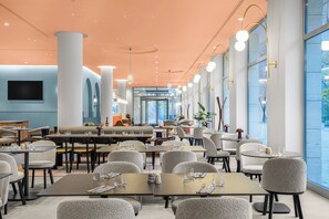 A modern restaurant with high ceilings, large windows, and a variety of seating arrangements. - Hotel Lycium Debrecen - Handwritten Collection (Debrecen)
