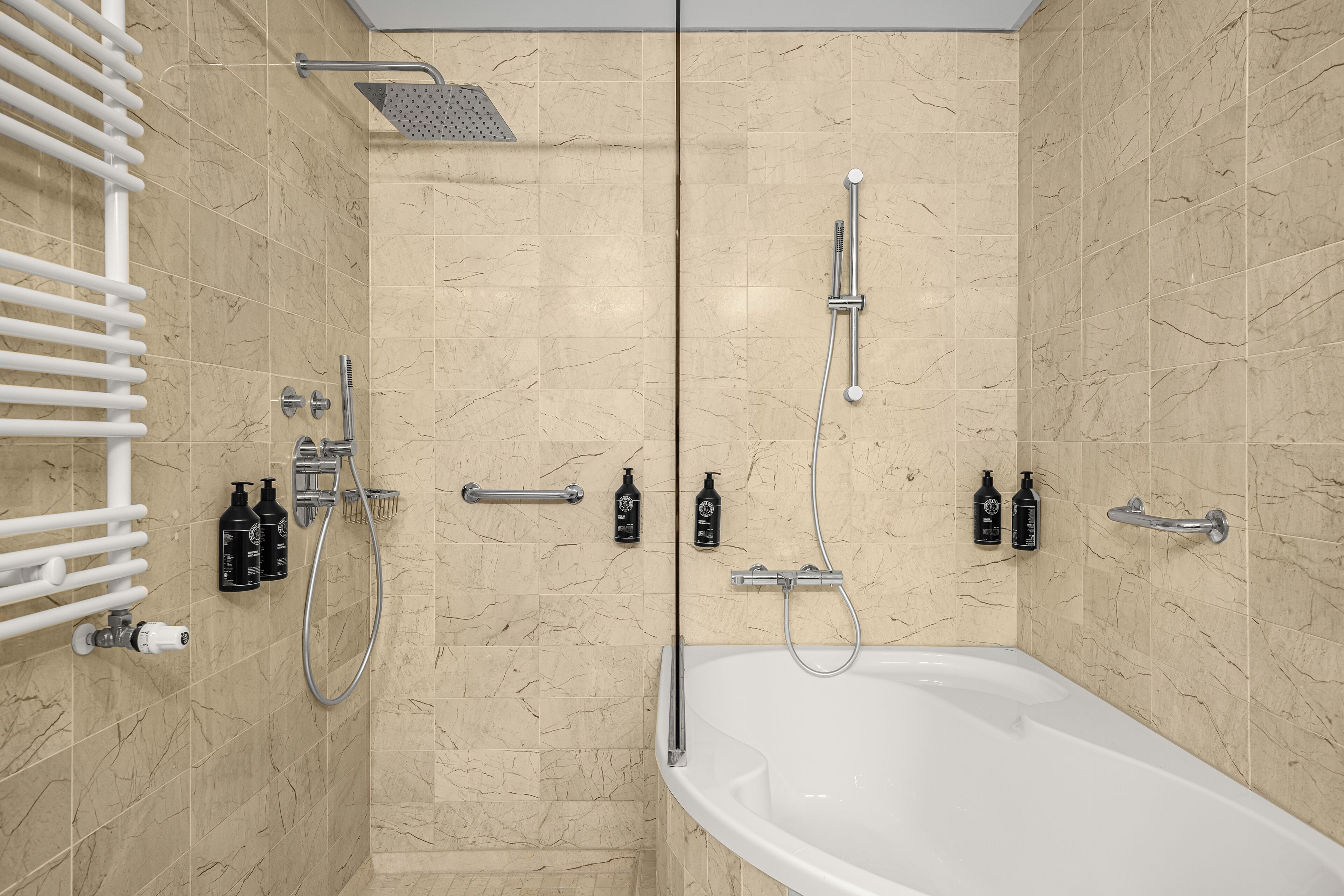 A modern bathroom with a bathtub, shower, and toilet.