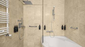 A modern bathroom with a bathtub, shower, and toilet.