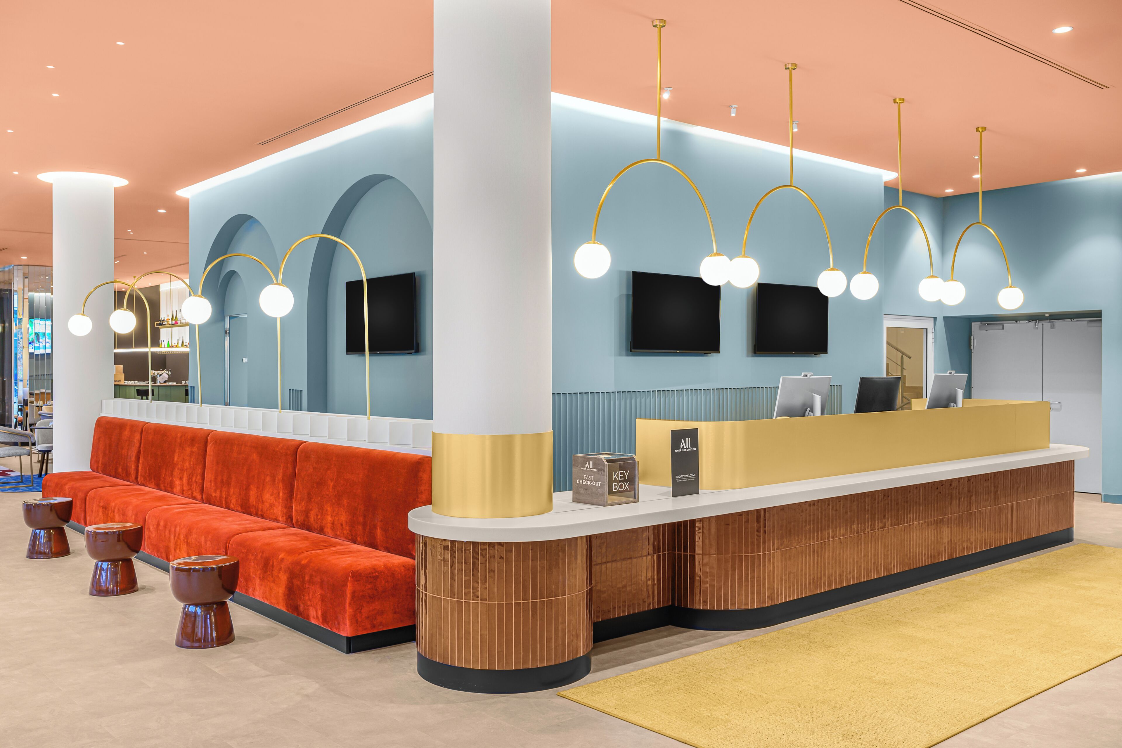 Un espace d’accueil au design moderne, comprenant un comptoir de réception, un coin salon et une grande colonne.