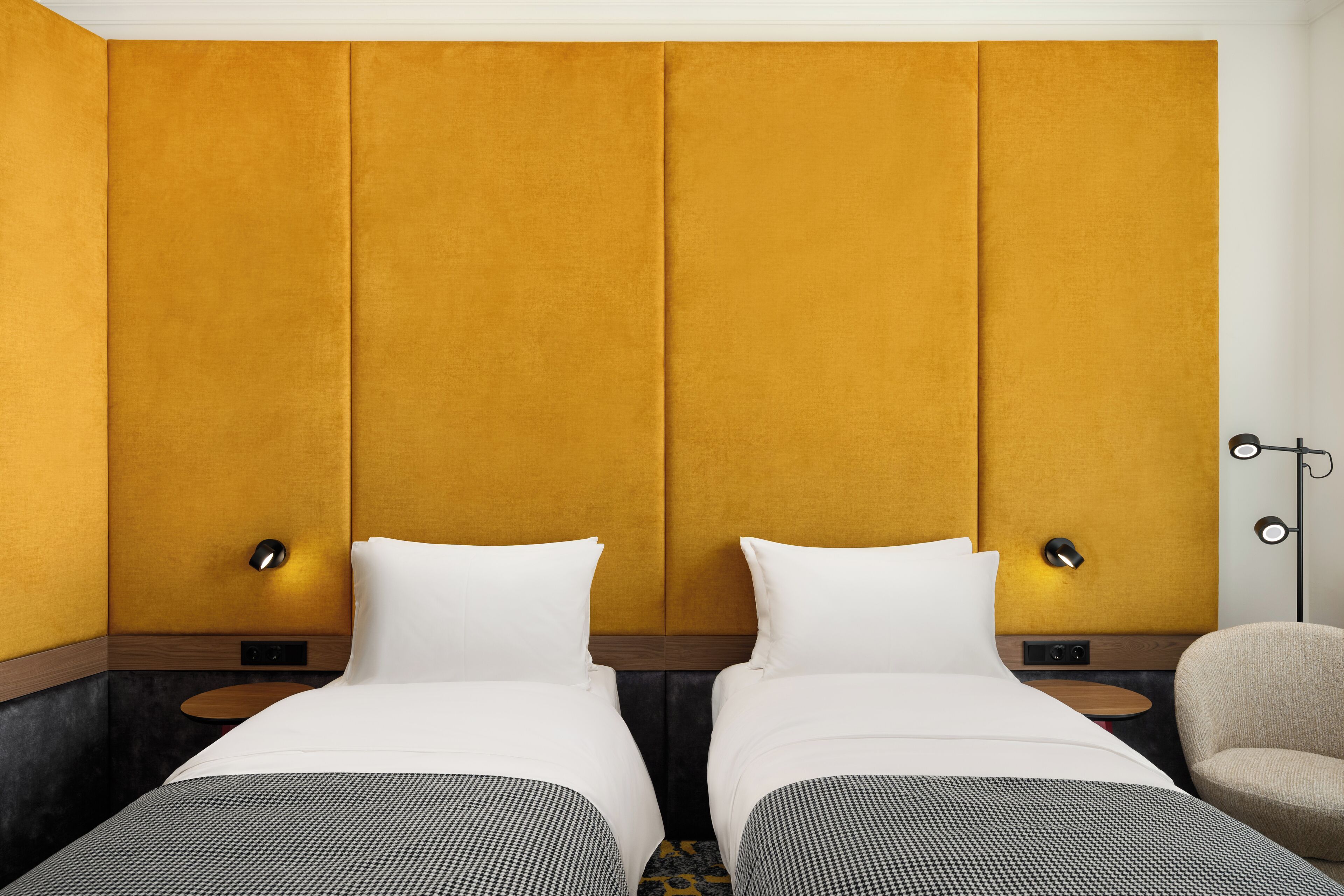 Ein Hotelzimmer mit zwei Betten, einem Schlafsofa und einem Sessel.