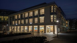 A modern hotel with multiple floors, large windows, and a well-lit entrance area. - Hotel Lycium Debrecen - Handwritten Collection (Debrecen)