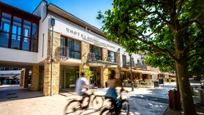 Un hôtel à la façade en pierre, doté de grandes fenêtres et d’une enseigne indiquant « HÔTEL EL GOLDEN LAKE RESORT ».