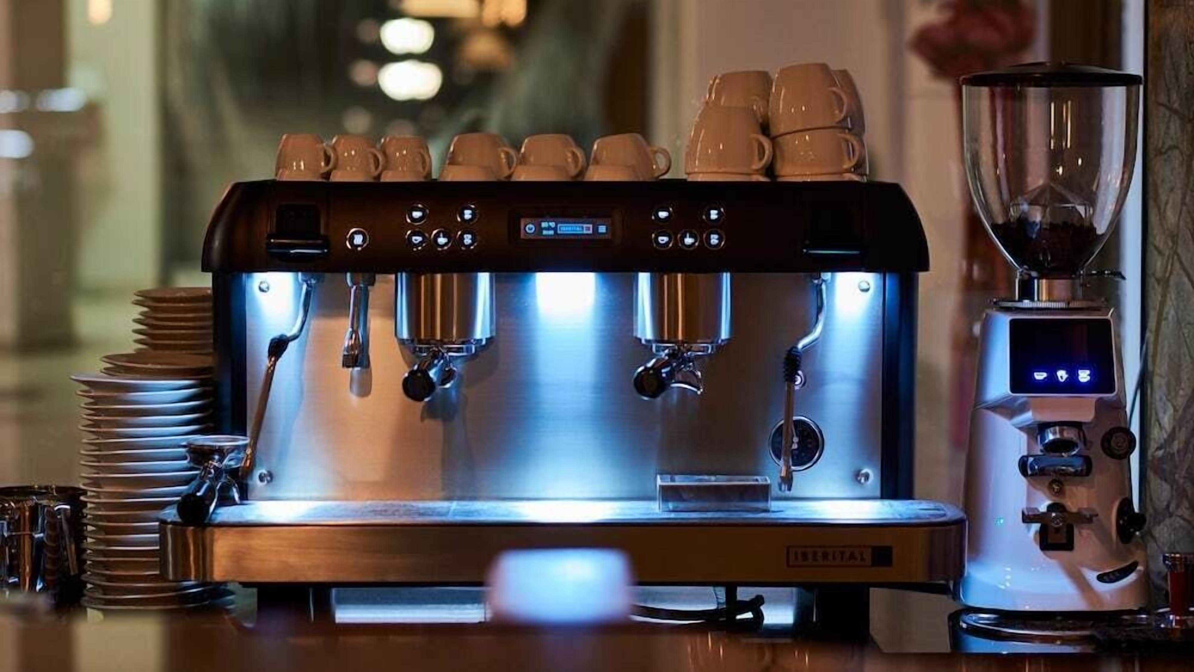 En professionell espressomaskin med flera kaffedispensrar, en digital display och en kaffekvarn.