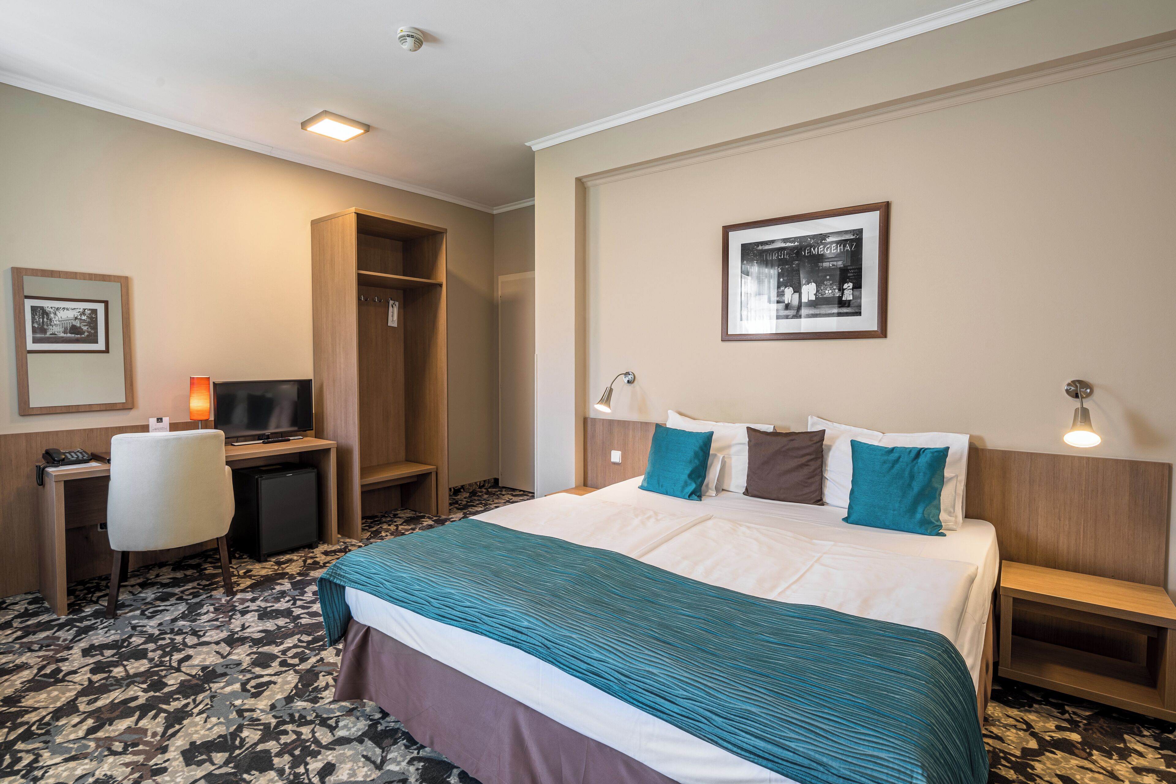 A hotel room with a bed, desk, and chair.