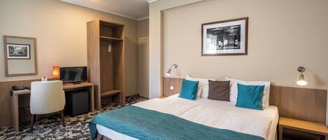 A hotel room with a bed, desk, and chair.