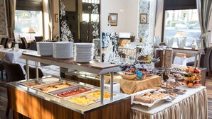 Un buffet proposant une variété de plats et où les assiettes sont empilées.