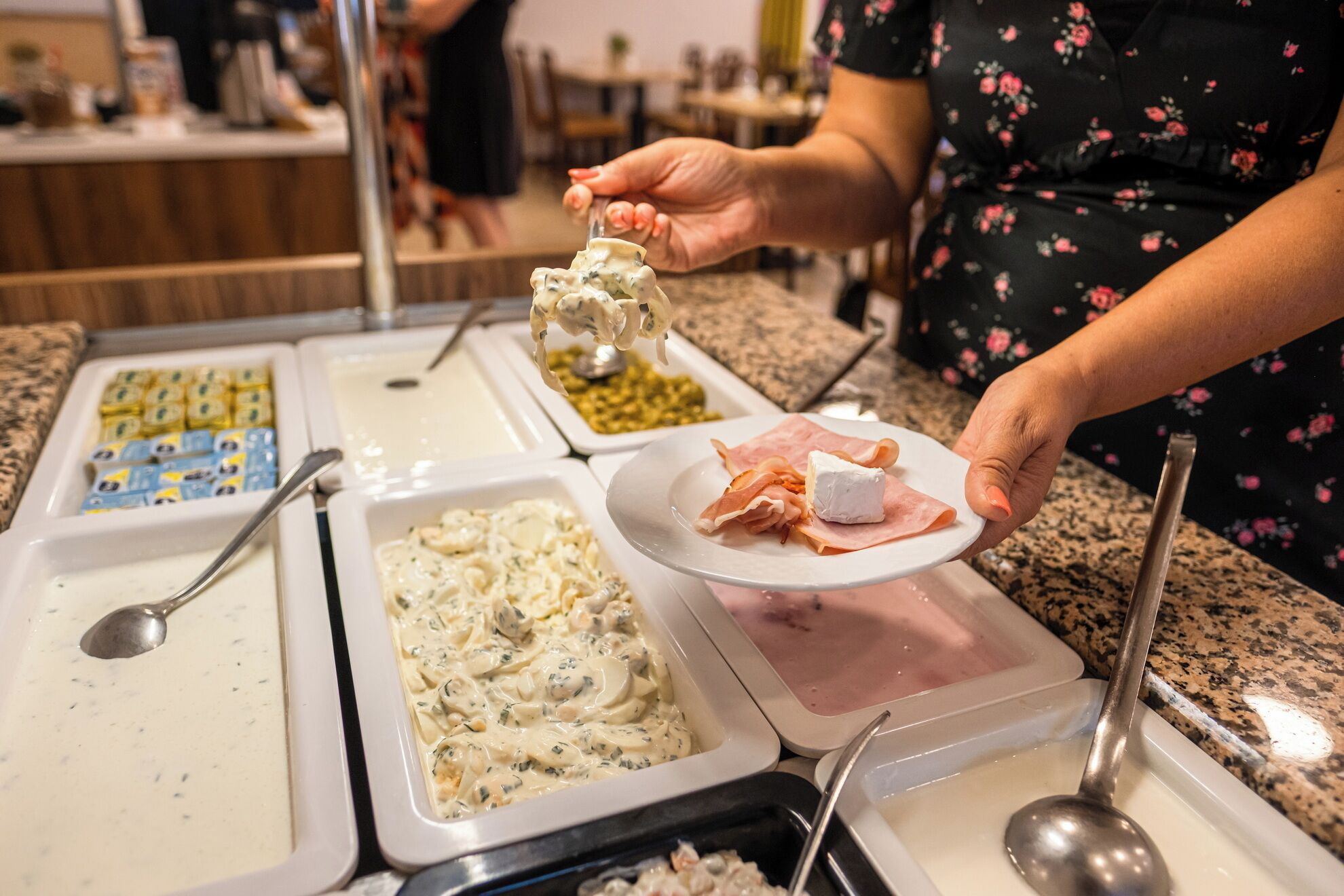 A buffet with various food items including pasta, cheese, and meats.