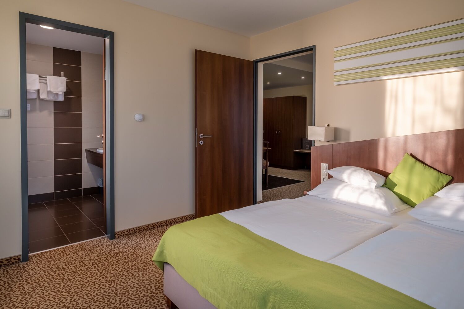 Una habitación de hotel con cama, baño y armario.