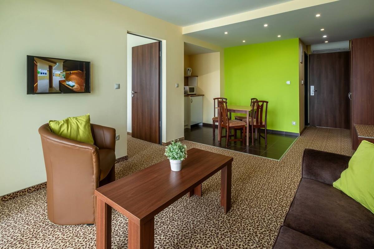 Une chambre d’hôtel comprenant un coin salon, un coin repas et une kitchenette.