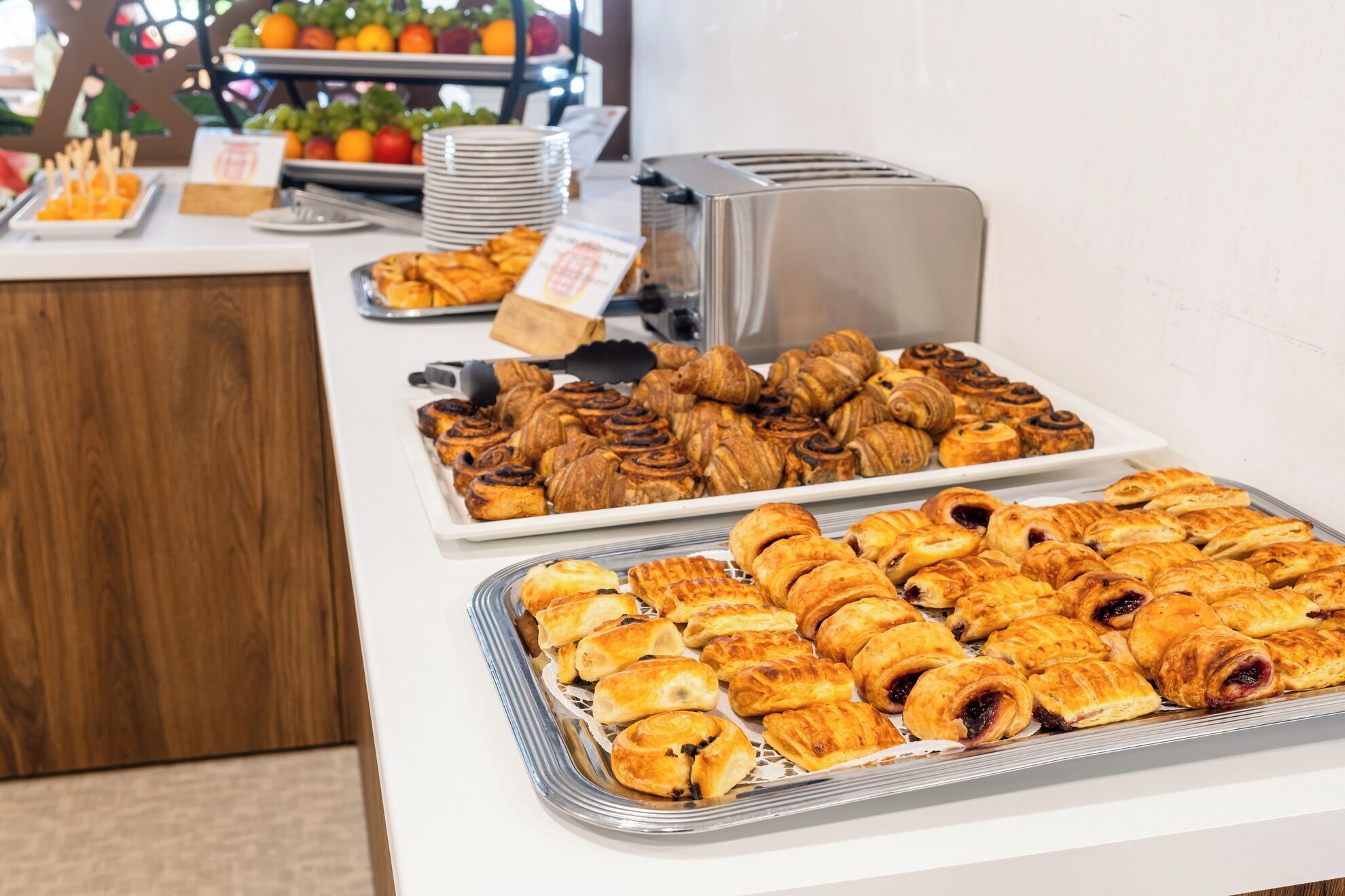 A buffet with various pastries and a toaster.