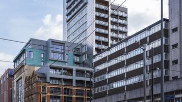 A multi-story building with a modern architectural design, featuring a mix of glass and brick facades.
