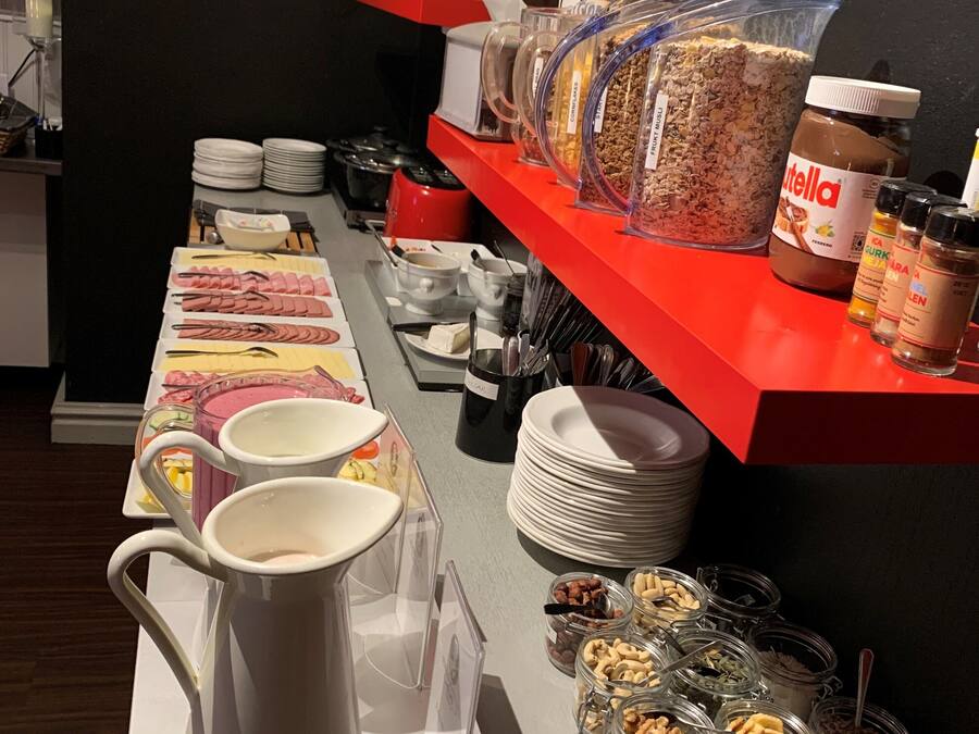 Un buffet proposant une variété de plats, notamment des pots de noix et de pâtes à tartiner, ainsi qu’un coin café.