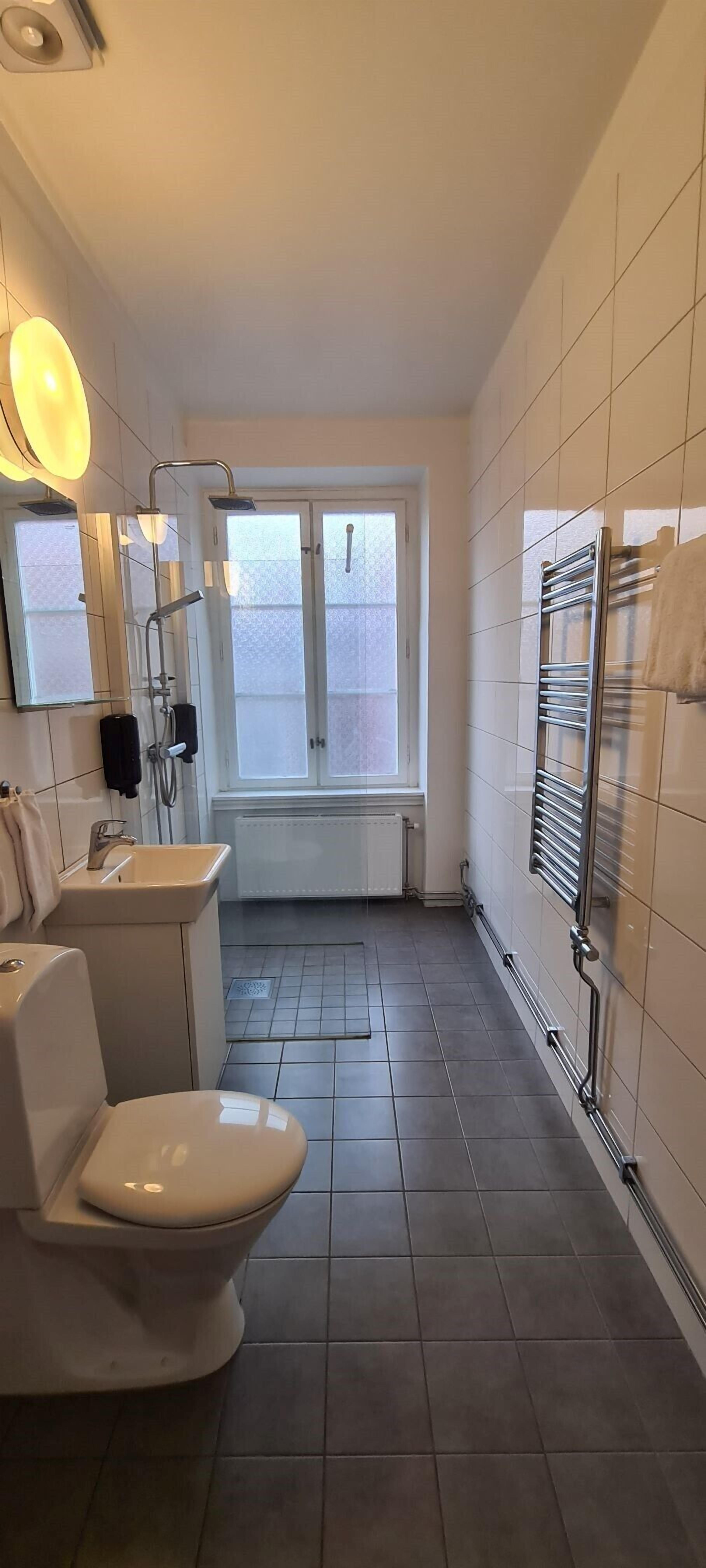 A modern bathroom with a toilet, sink, and shower.