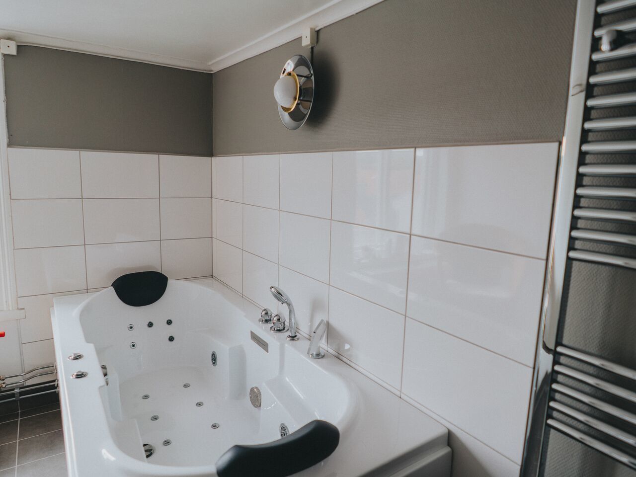 A modern bathroom with a freestanding bathtub, a wall-mounted towel rack, and a built-in shower area.