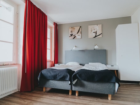Escritorio, cortinas blackout y tabla de planchar con plancha