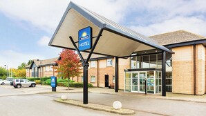 A Days Inn hotel with a covered entrance, a parking area, and a brick building facade. - Days Inn by Wyndham Peterborough (Peterborough)