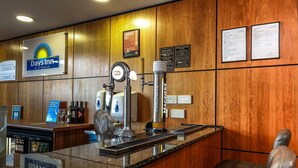 A reception area with a bar, a sign for 'Days Inn by Wyndham,' and a 'Under 25' age restriction notice. - Days Inn by Wyndham Peterborough (Peterborough)