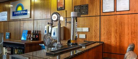 A reception area with a bar, a sign for 'Days Inn by Wyndham,' and a 'Under 25' age restriction notice.