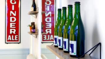 A shelf with several green wine bottles labeled "Lambic Bio" and a red sign in the background reading "GINDER ALE".