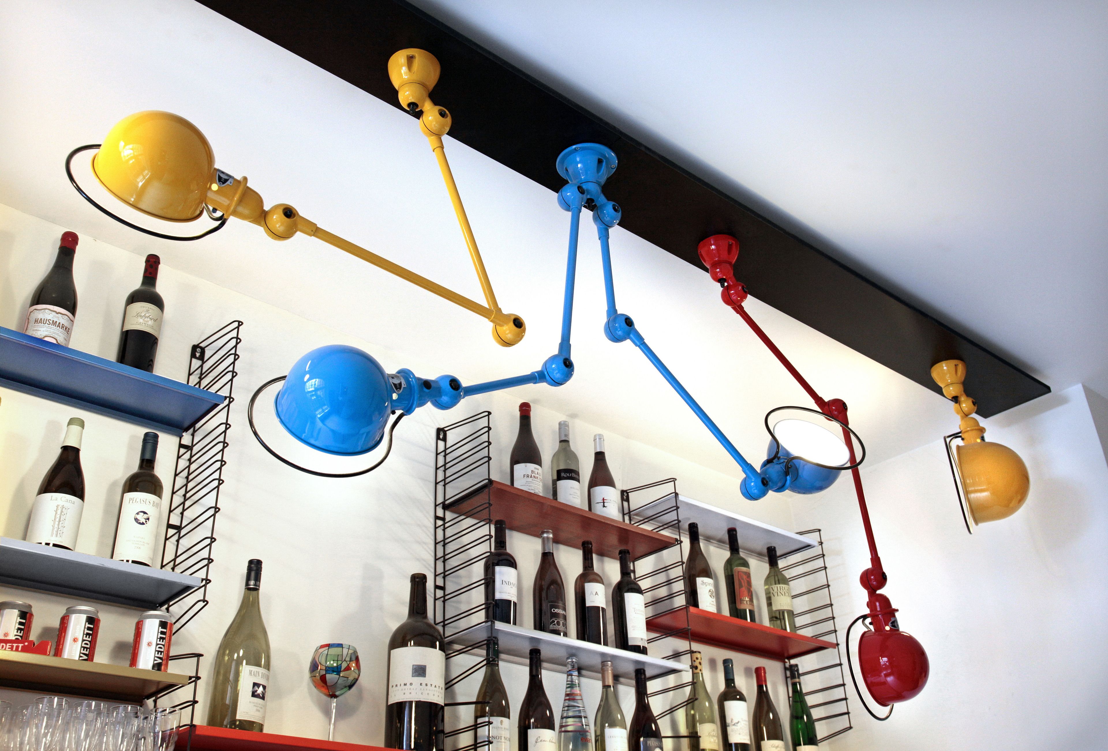 A wine rack with various bottles and a hanging light fixture.