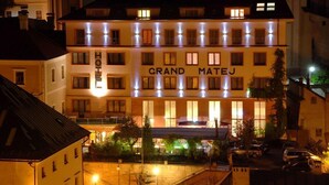 Ein mehrstöckiges Hotel, dessen Fassade den Schriftzug "GRAND MATEJ" zeigt.
