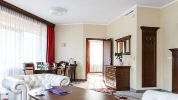 A hotel room with a dining area, a large mirror, and a wooden cabinet.