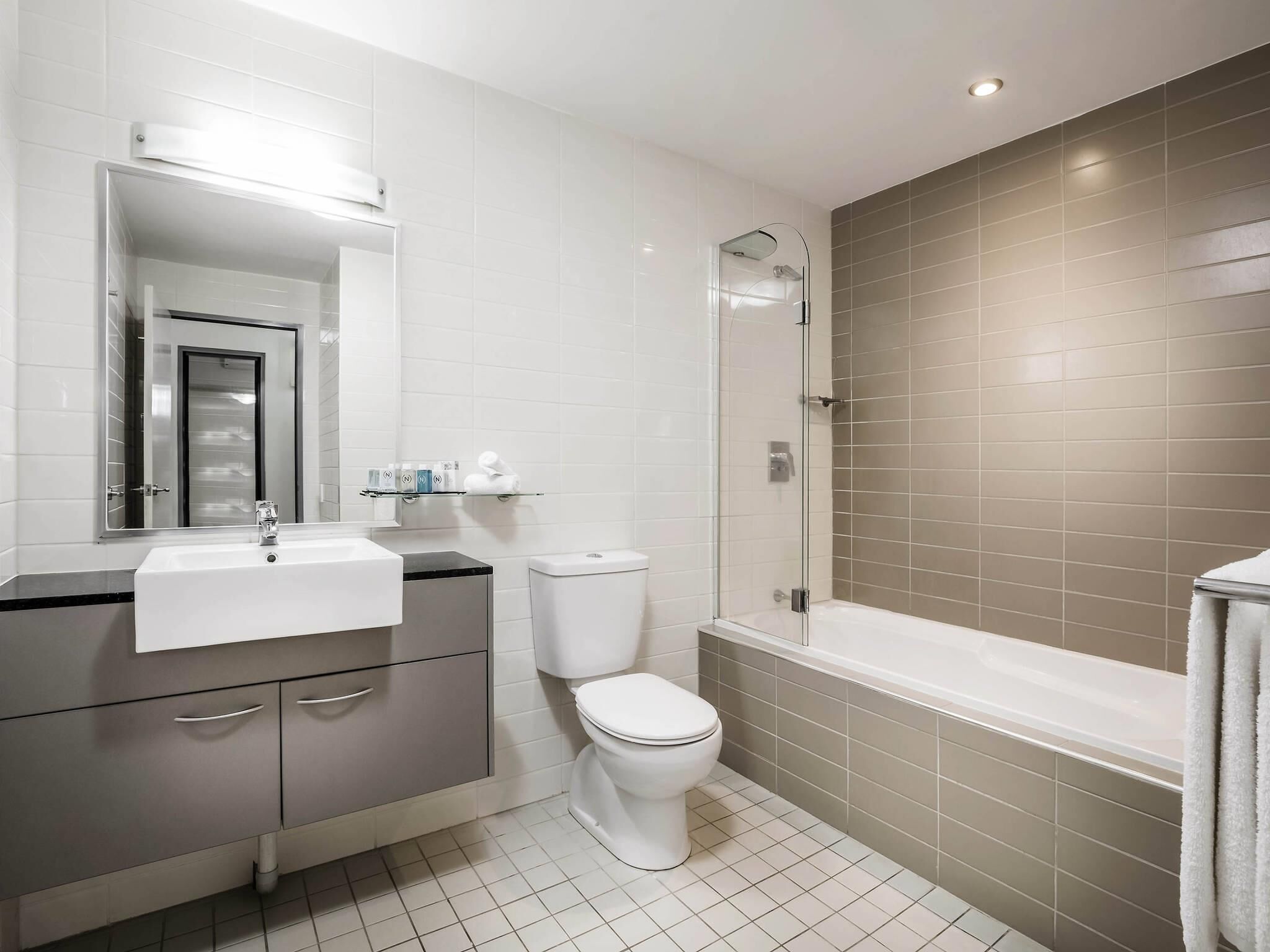A modern bathroom with a sink, toilet, and shower.