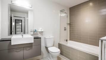 Een moderne badkamer met een wastafel, toilet en douche.