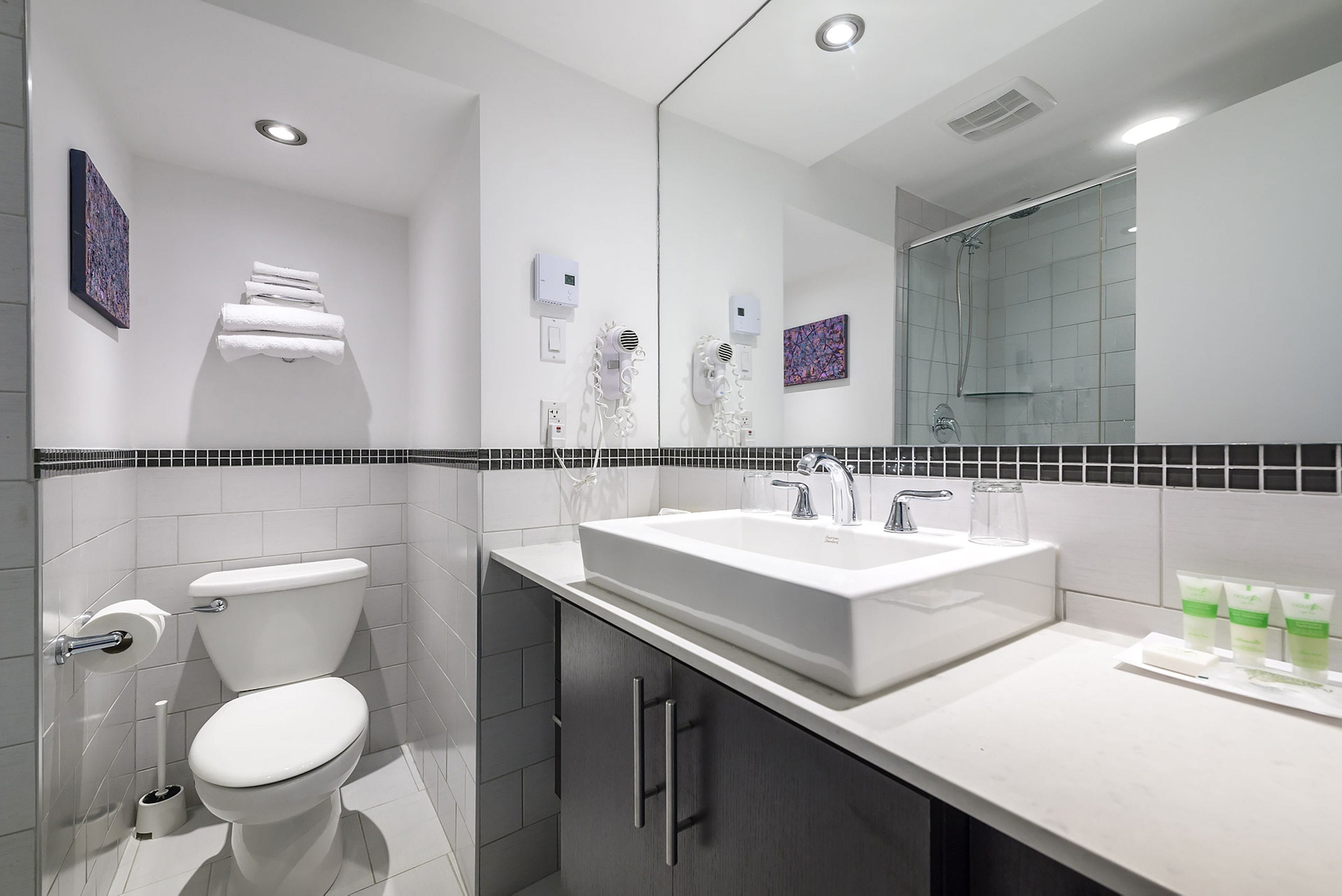 Ein modernes Badezimmer mit Toilette, Waschbecken und Dusche.