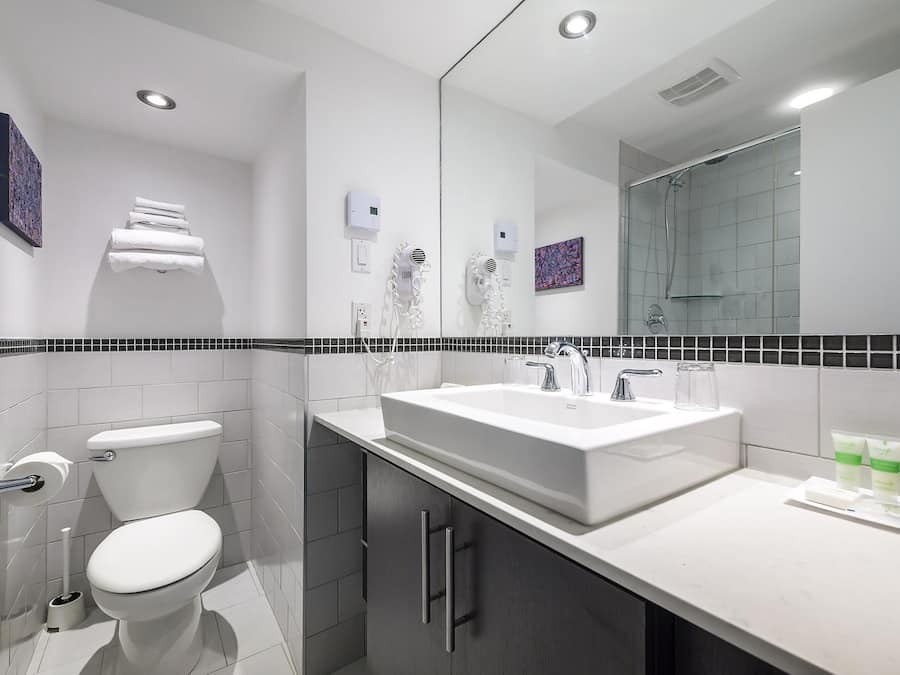 Un baño moderno con inodoro, lavamanos y ducha.