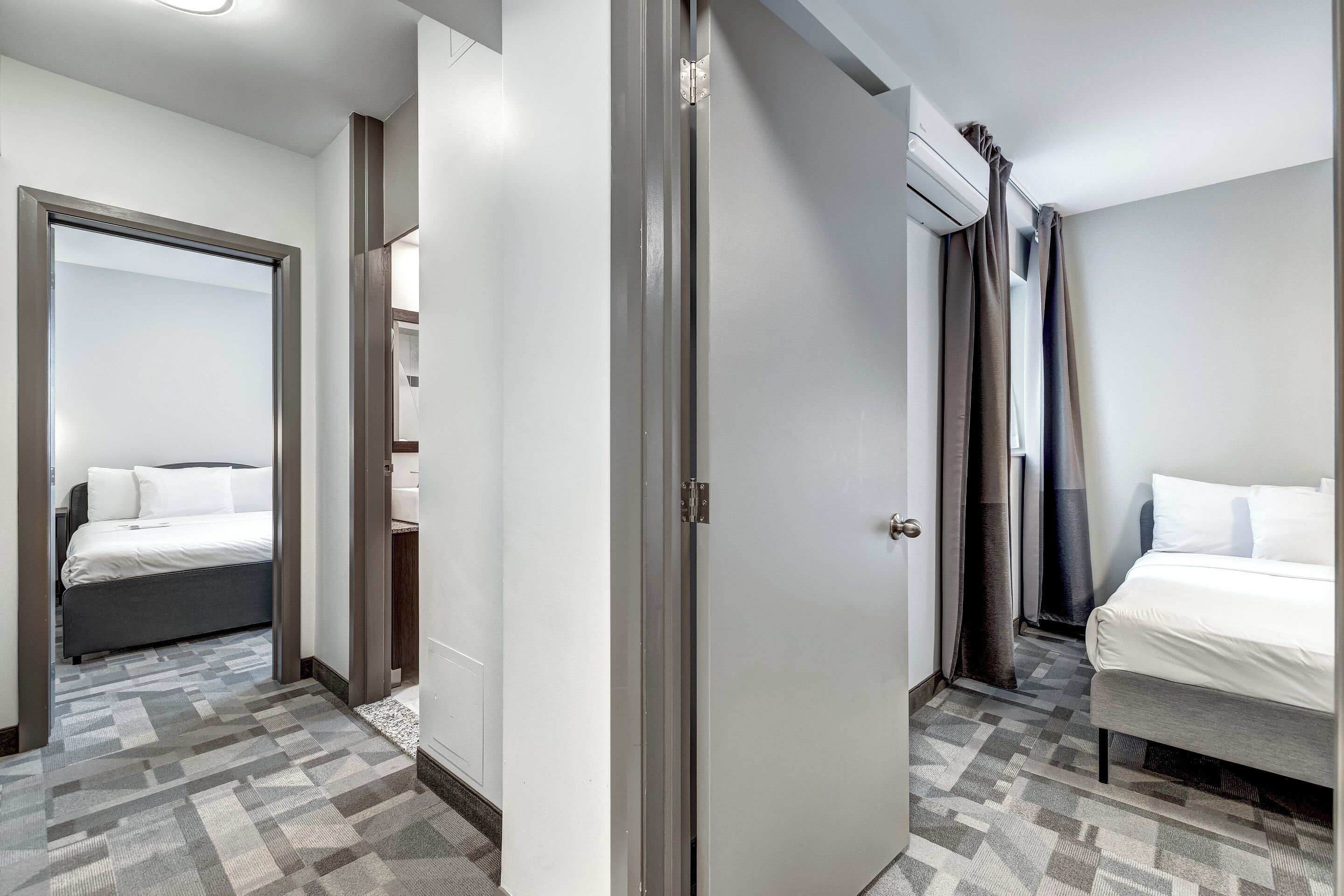 Habitación de hotel con cama, armario y baño.