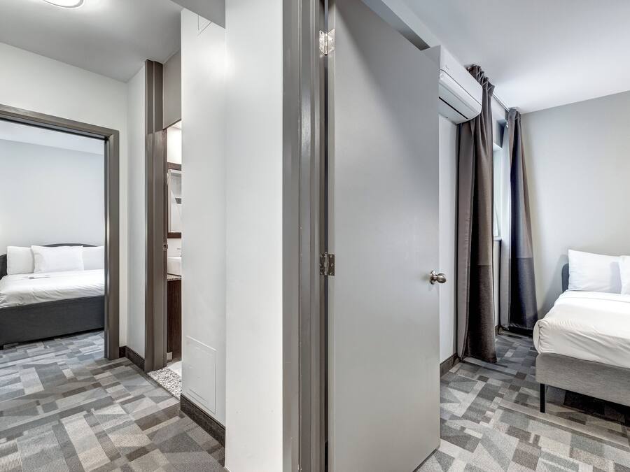 Habitación de hotel con cama, armario y baño.