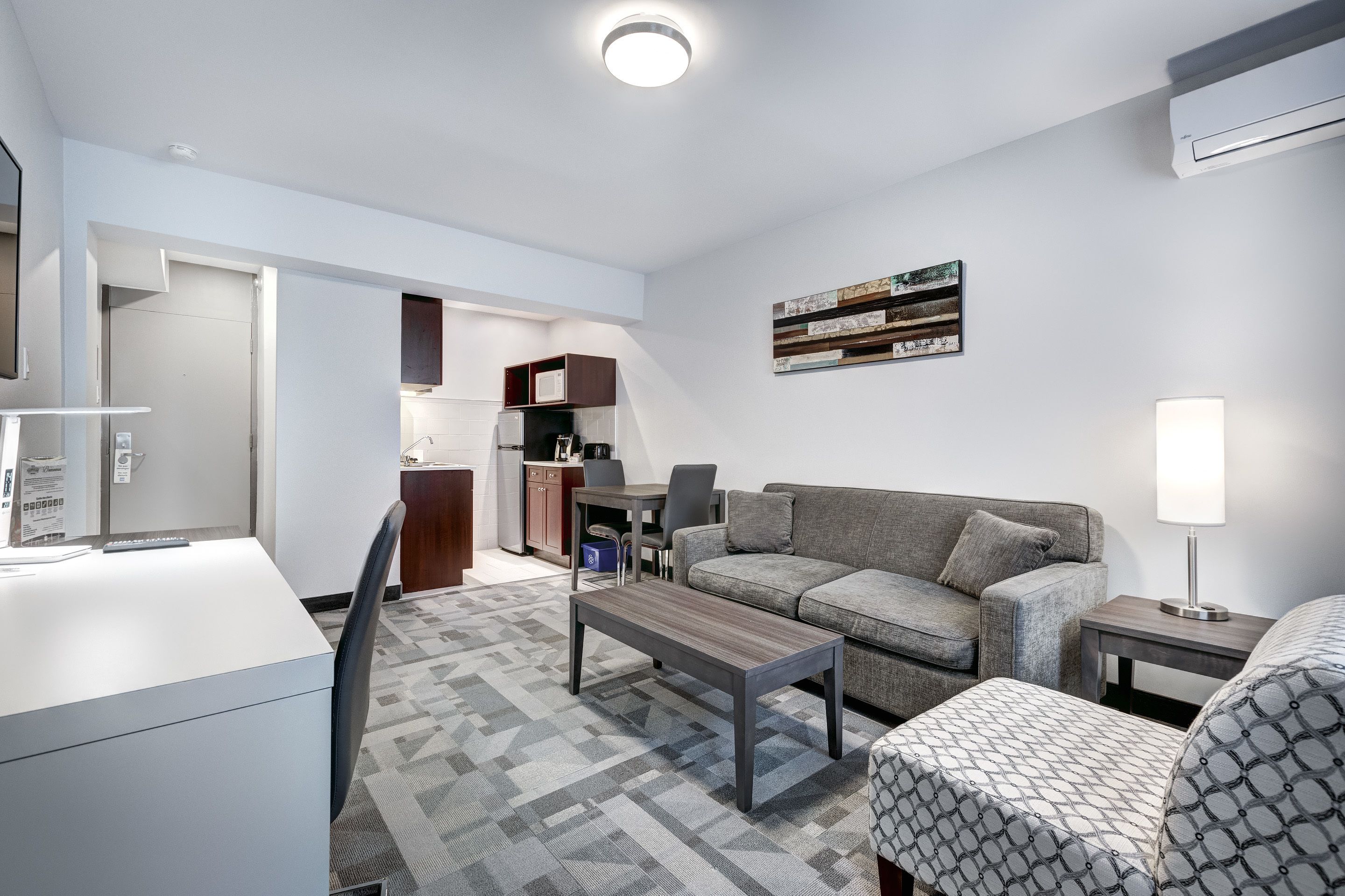 A modern living room with a sofa, coffee table, and a dining area with a table and chairs.