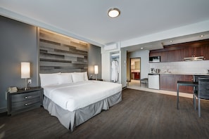 A modern hotel room with a large bed, bedside tables, a desk, and a kitchenette. - Hotel Terrasse Royale (Montreal)