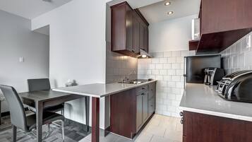 A modern kitchen with dark wood cabinets, a stainless steel sink, and a built-in oven.