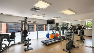 A gym with exercise equipment, a treadmill, and exercise balls.
