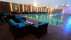 An indoor swimming pool area with lounge chairs and a tiled floor. - Novotel Yanbu (Yanbu)