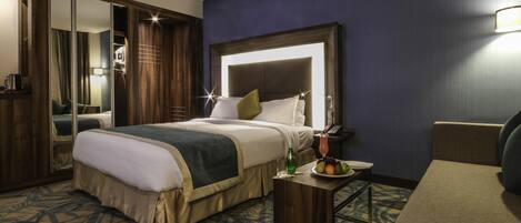 A hotel room with a bed, bedside table, and a chair.