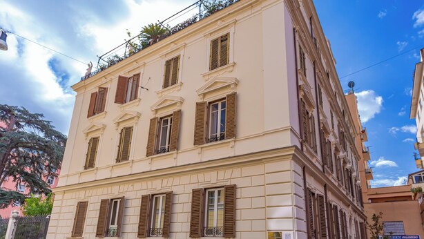 Un edifici de diverses plantes d'estil arquitectònic clàssic, amb finestres simètriques i un balcó al pis superior.