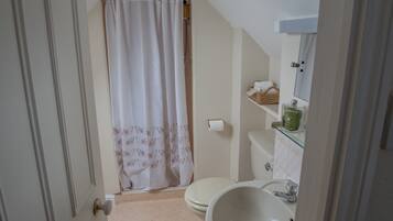Un baño con inodoro, lavabo y cortina de ducha.