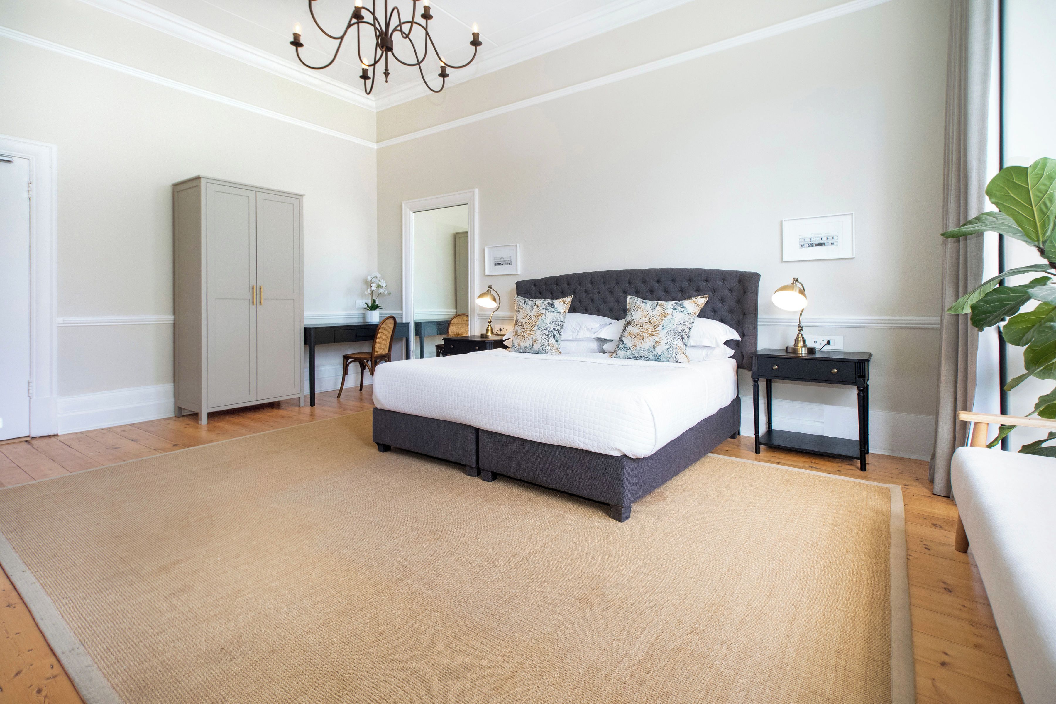 Une chambre à coucher avec un grand lit, une armoire, un bureau et une table de chevet.