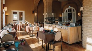 Un restaurante con arcos de ladrillo, mesas y sillas de madera.